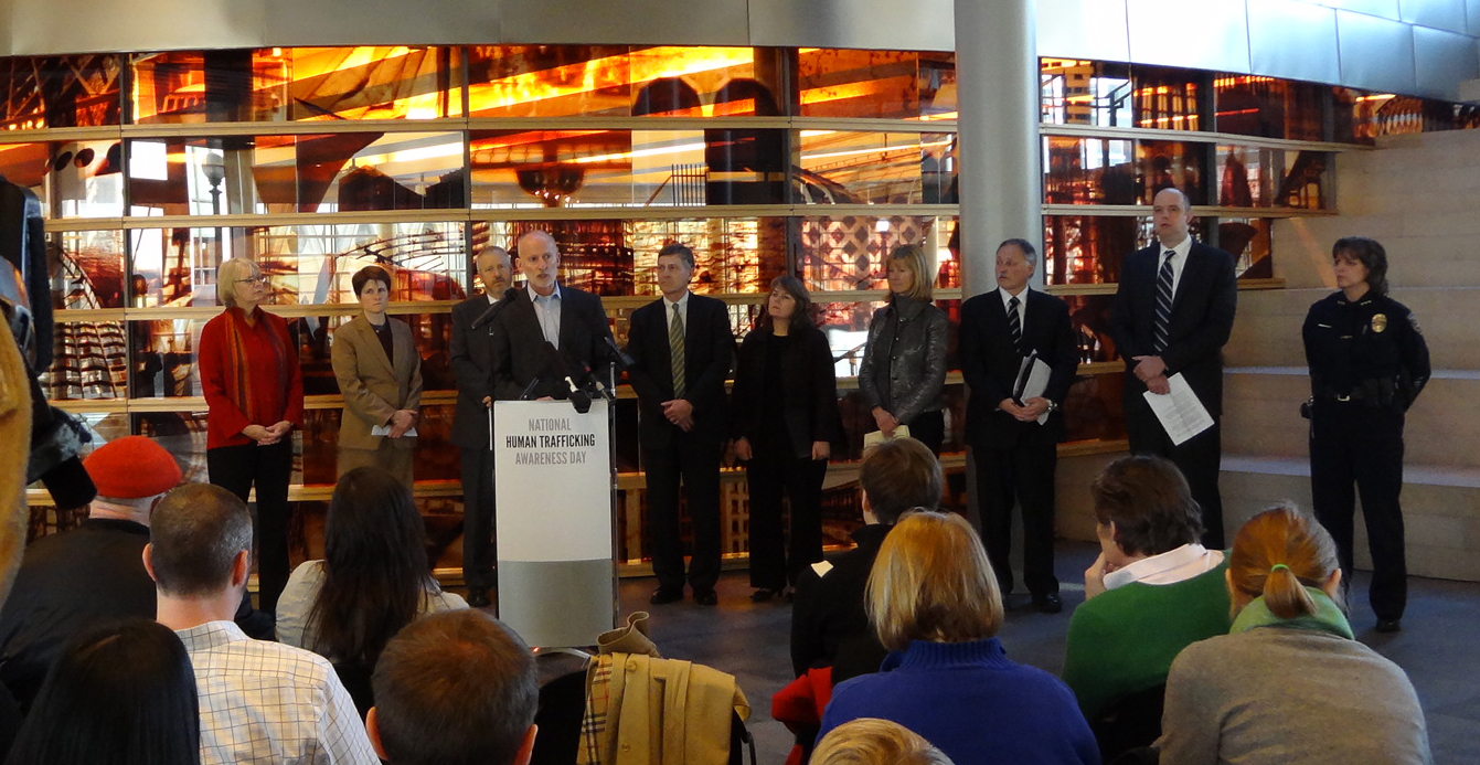 Officials at a National Human Trafficking Awareness Day event, with a speaker at a podium