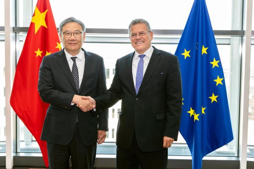 Chinese Commerce Minister Wang Wentao and EU Trade Commissioner Maros Sefcovic meeting between China and EU flags
