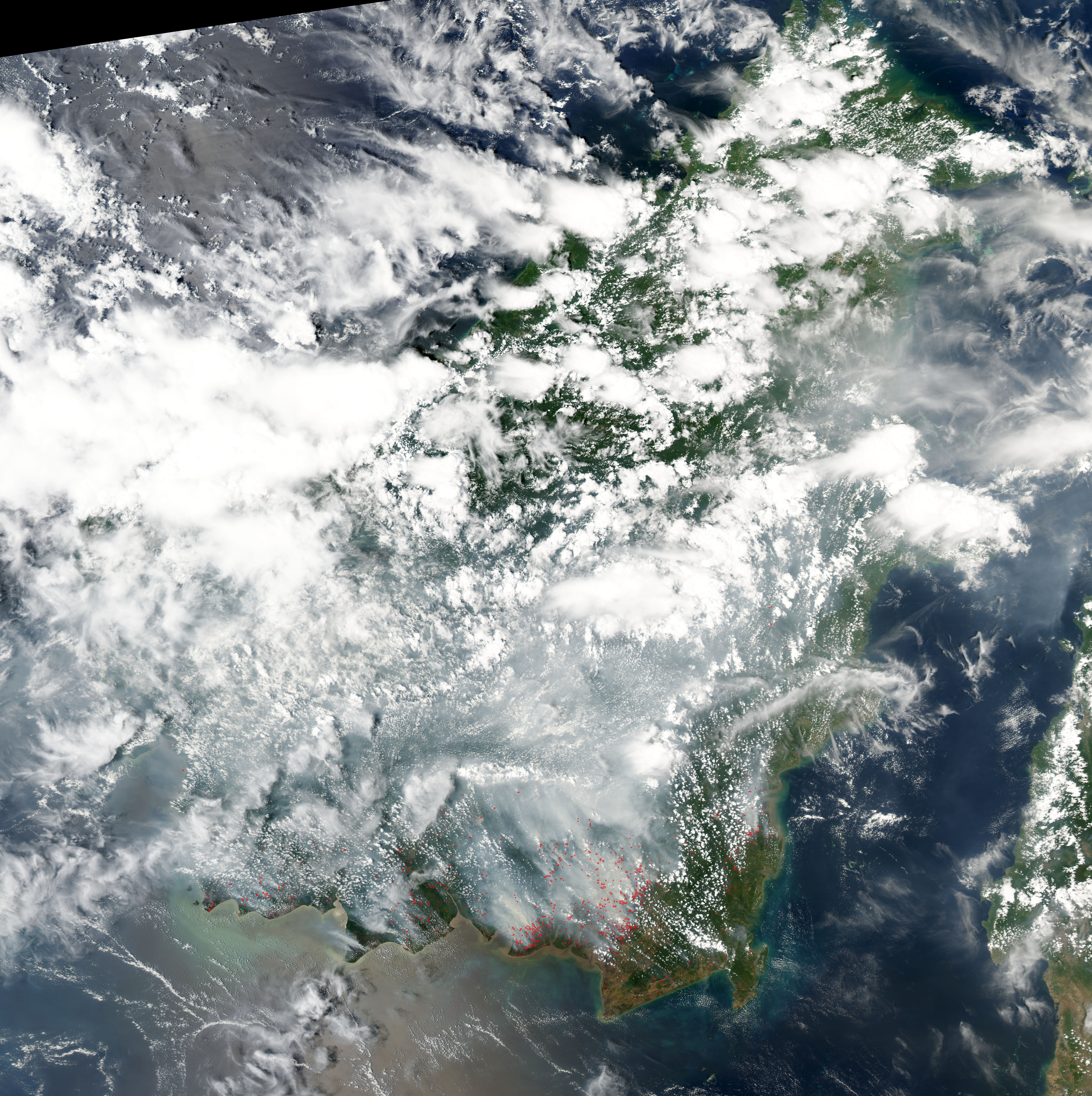 NASA satellite image showing wildfire smoke and fire hotspots across Borneo and Sumatra during Indonesia's 2026 fire season, the most intense in 11 years