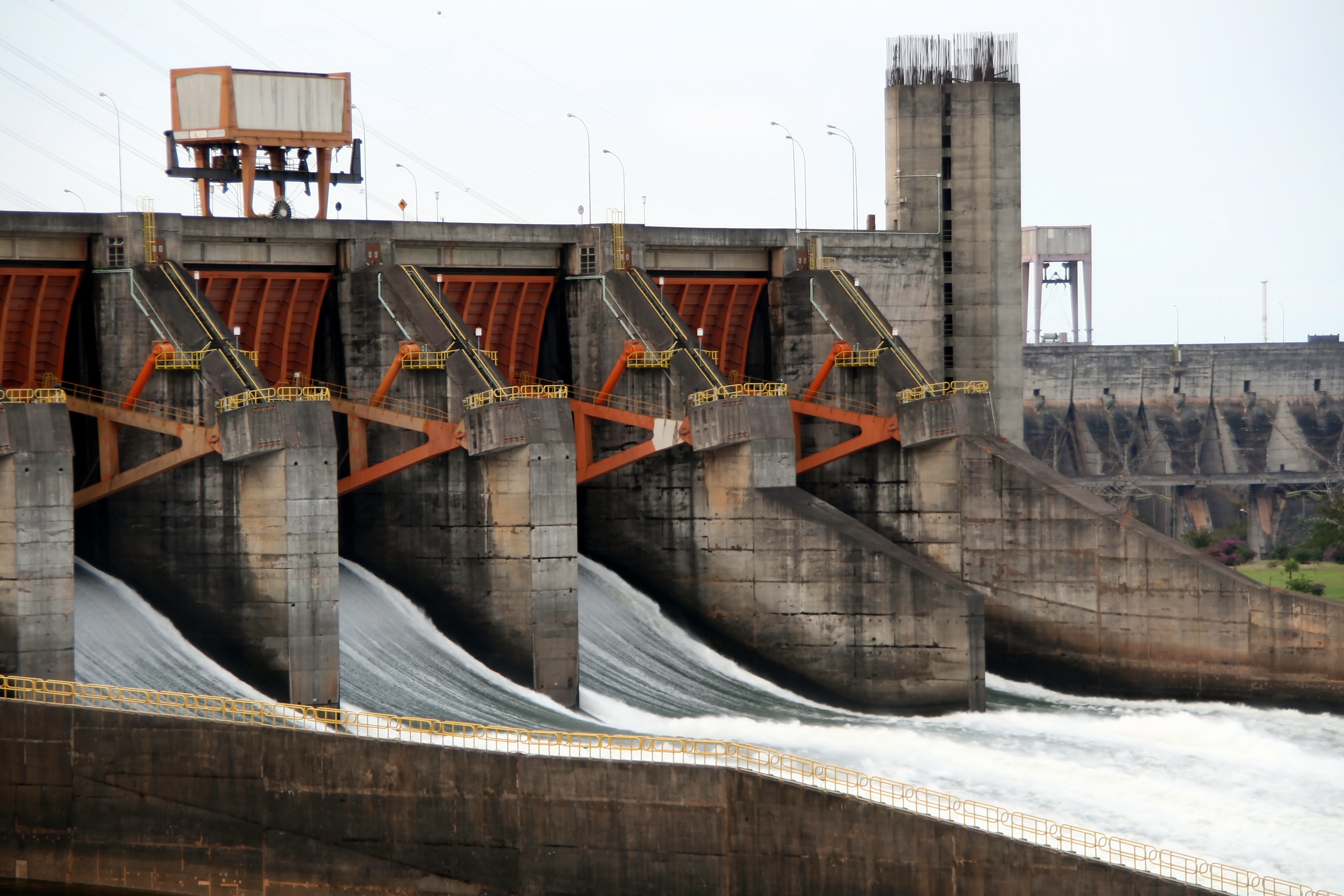 Water discharging through the red spillway gates of the Itaipú Dam on the Paraná River between Paraguay and Brazil