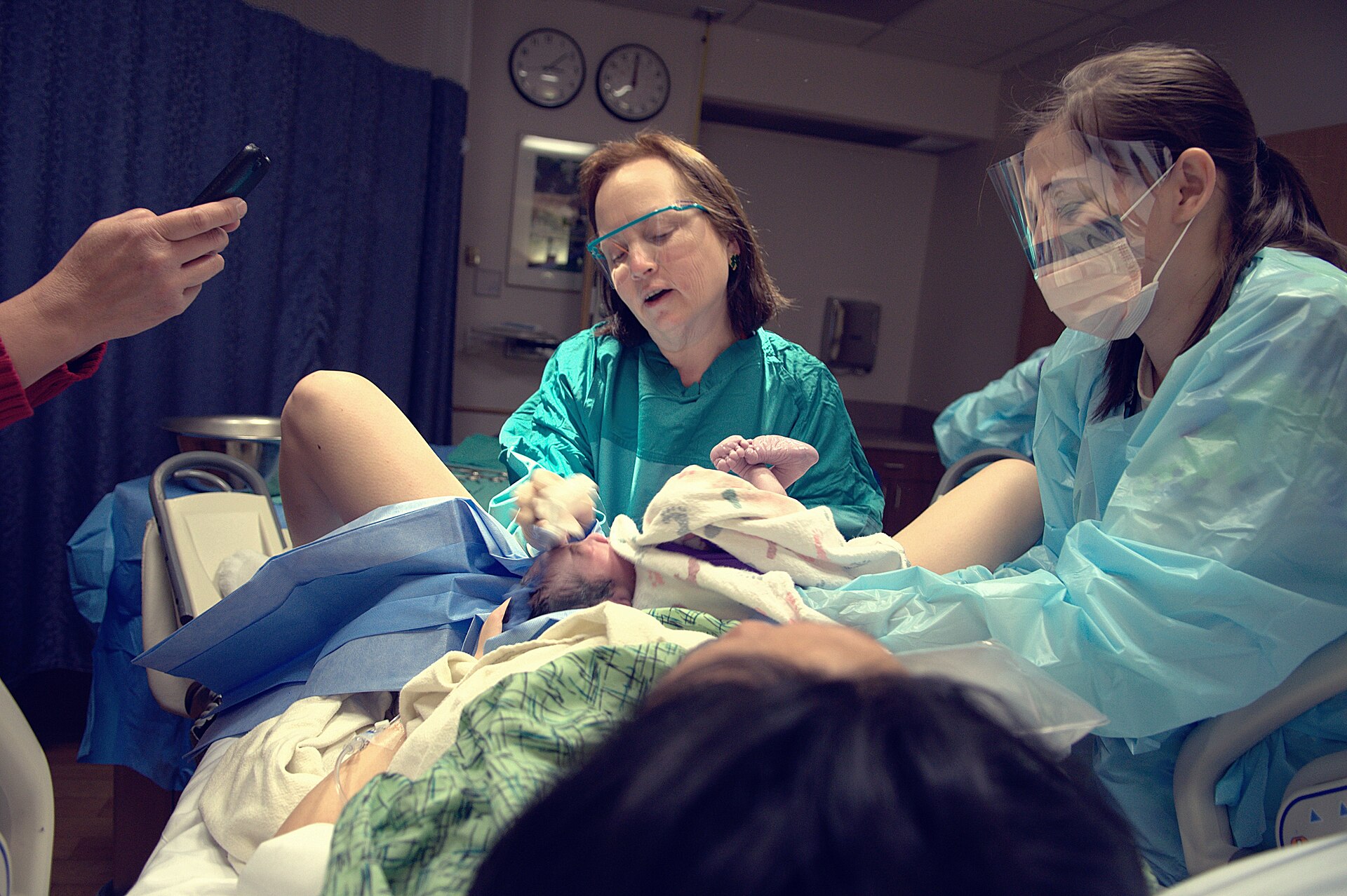 Delivery team with a newborn in a hospital labour and delivery room — maternity ward closures Medicaid file photo