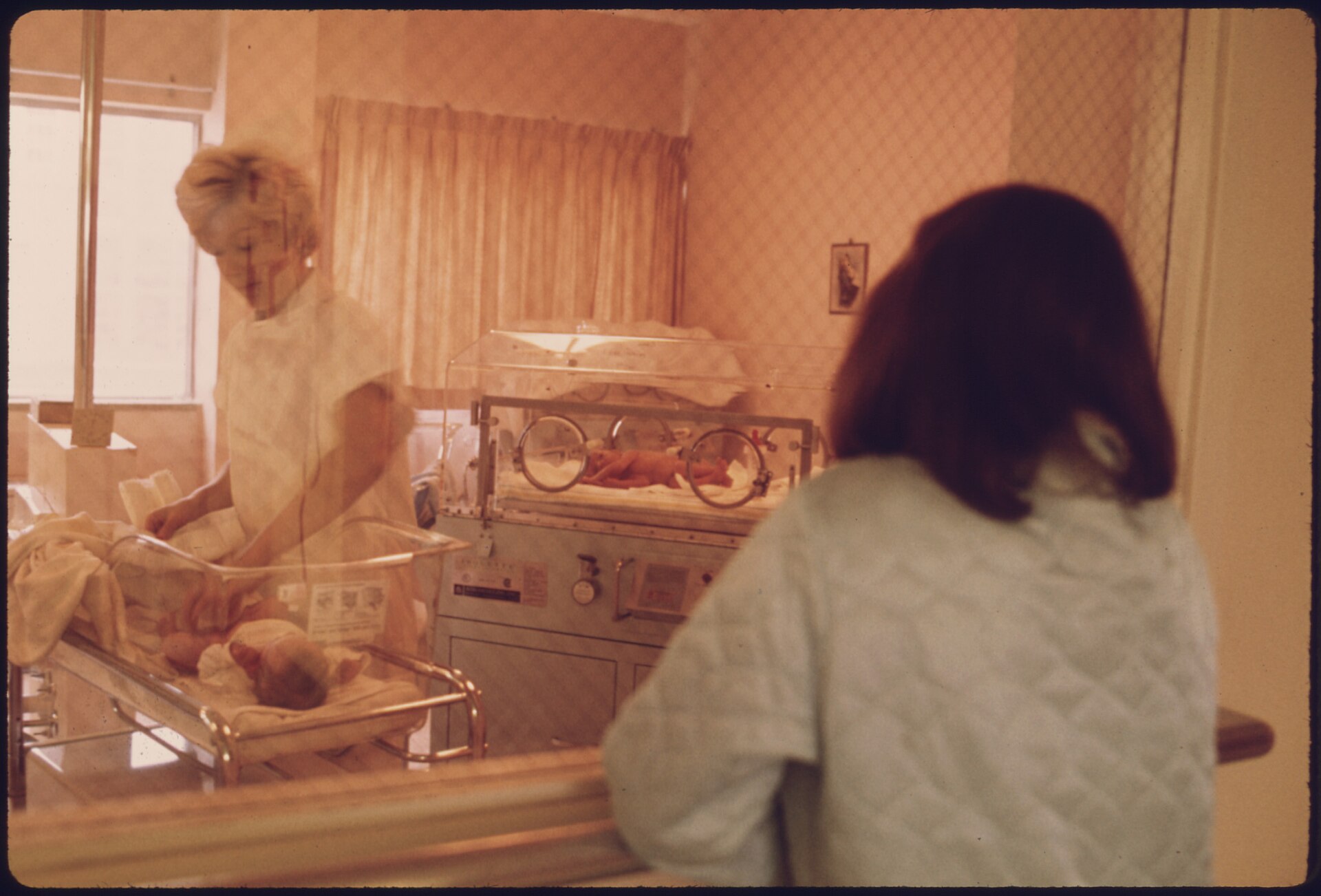 Mother viewing her newborn in a small-town hospital nursery in New Ulm, Minnesota — rural maternity care access
