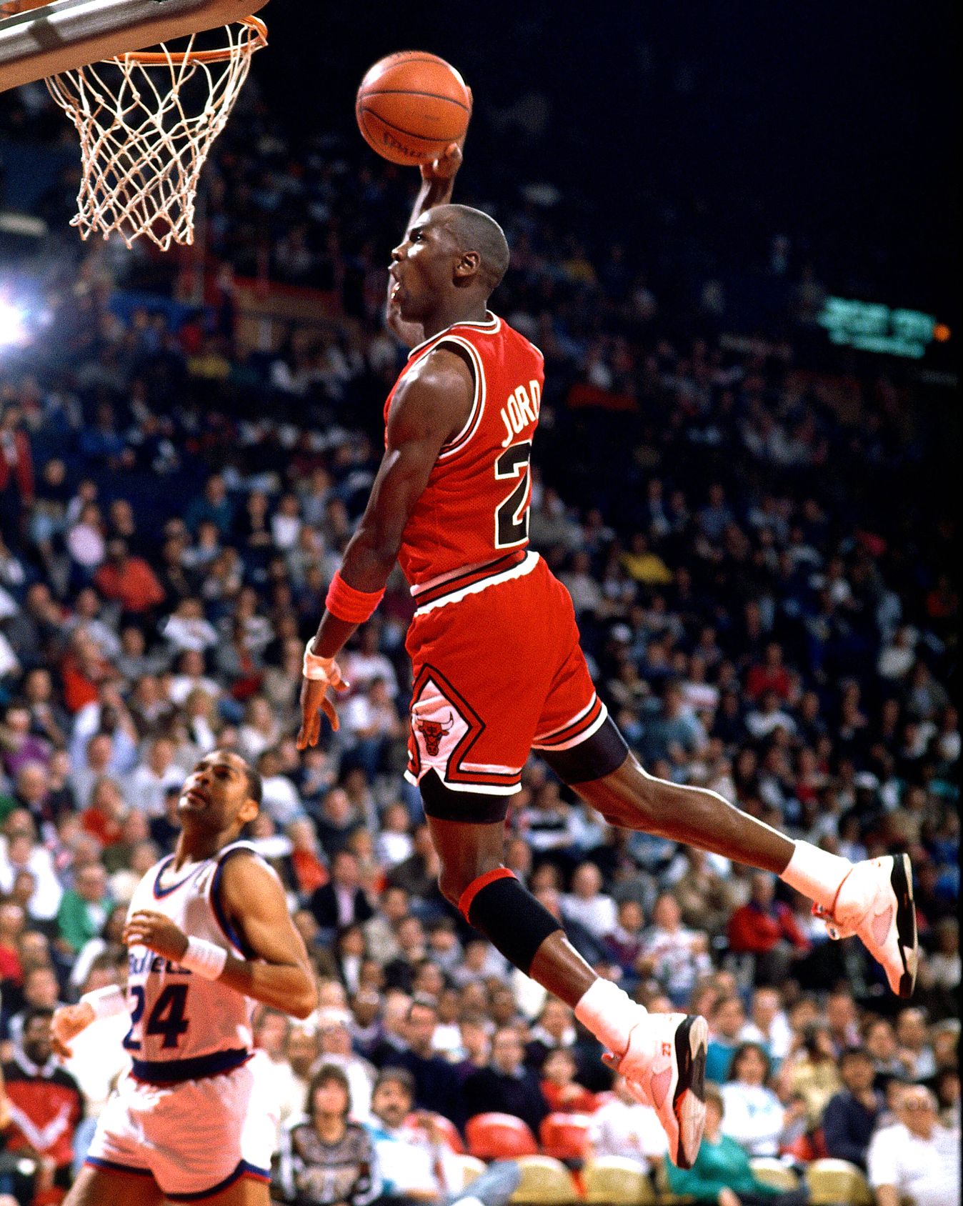 Michael Jordan mid-dunk in the red Chicago Bulls road uniform during his Bulls prime