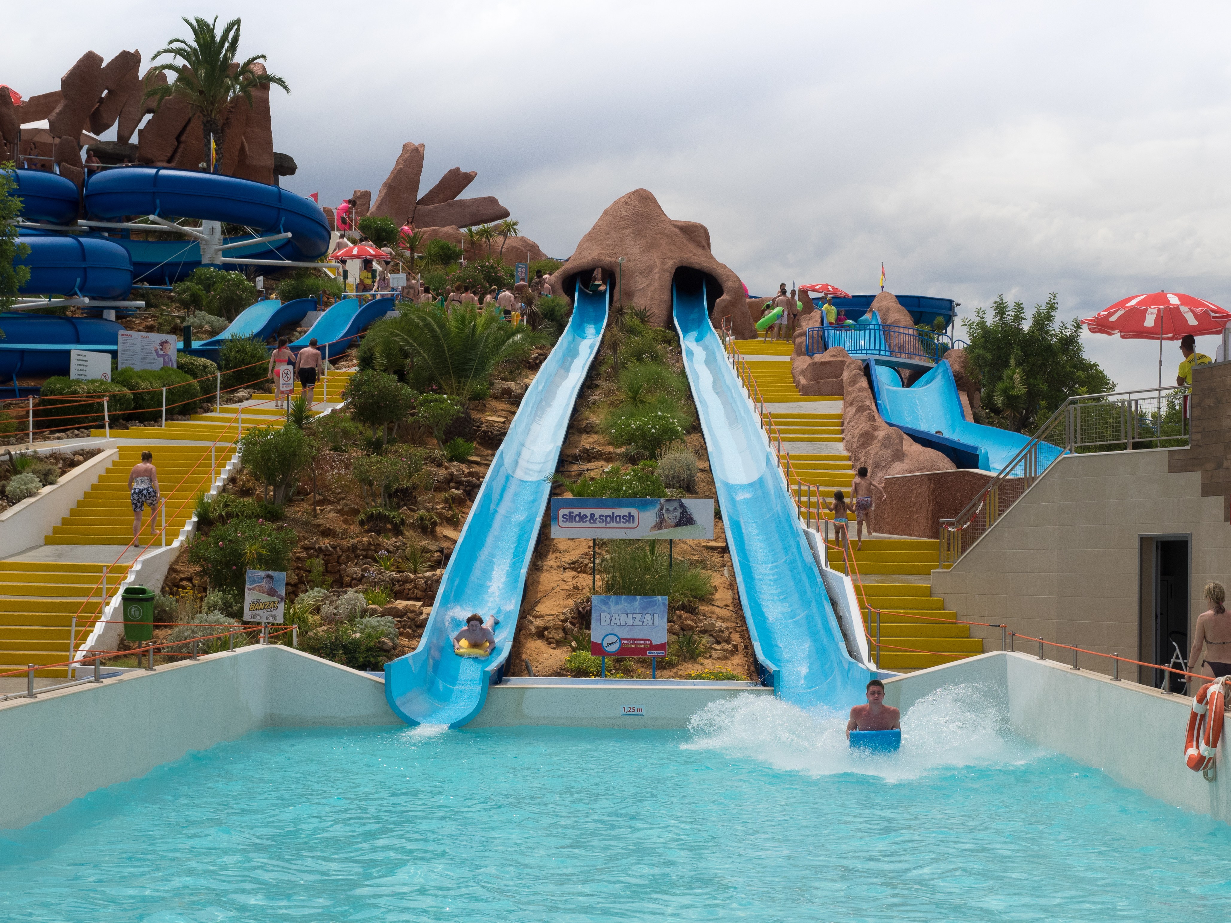 Guests descending parallel outdoor waterslides