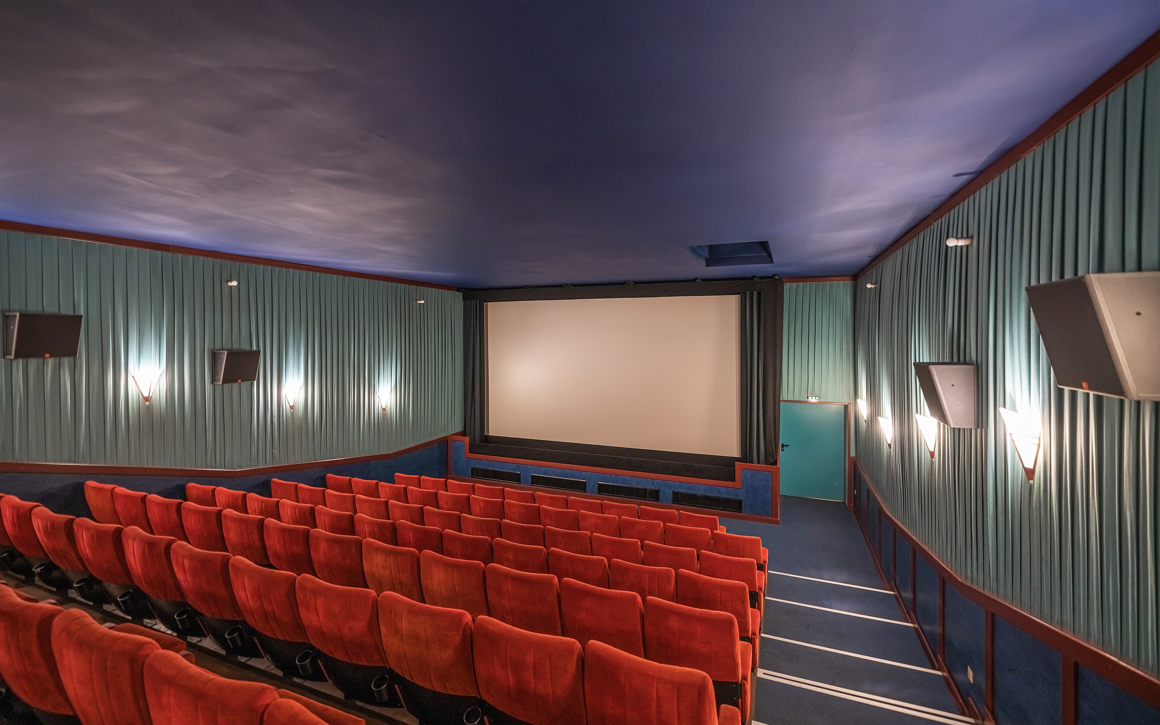 Rows of red seats inside a cinema auditorium