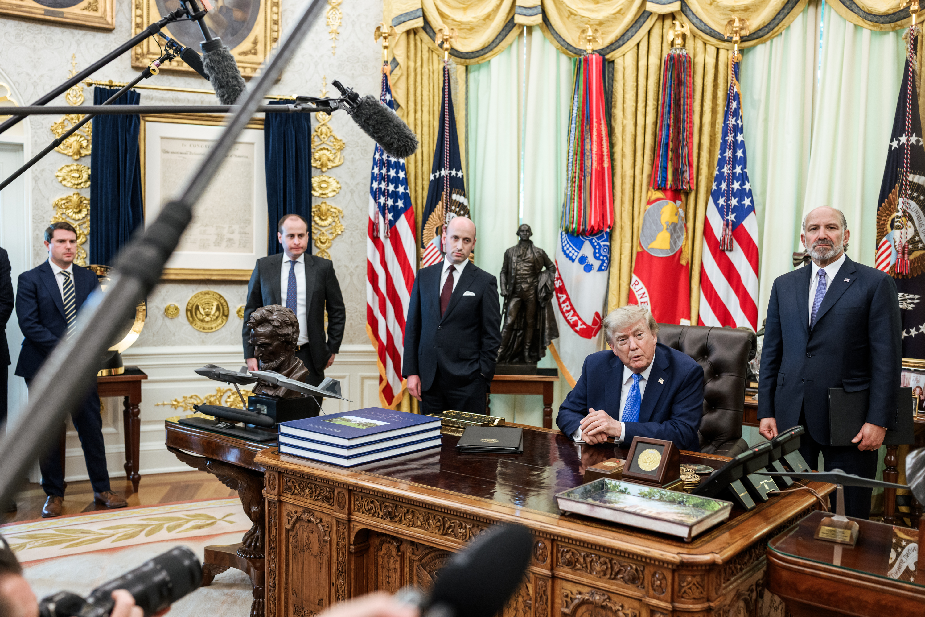 President Trump signing executive orders in the Oval Office alongside Deputy Chief of Staff Stephen Miller and Commerce Secretary Howard Lutnick
