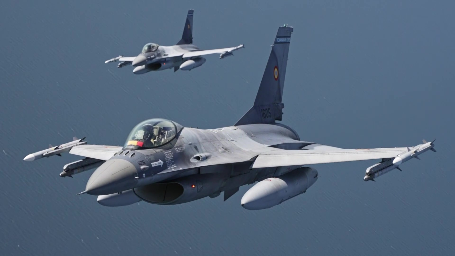 Two Romanian Air Force F-16s in flight over the sea — Romania shoots down drones with F-16s scrambled from Borcea