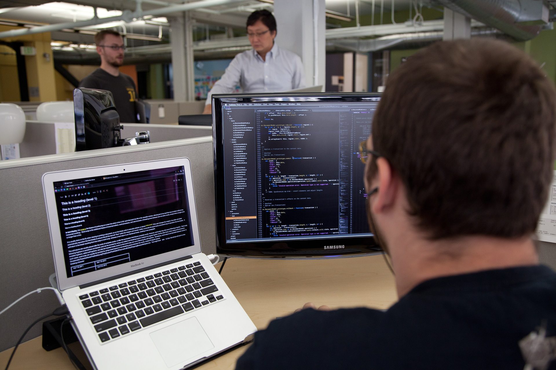 A programmer reviewing code on screen — AISLE's AI hunts vulnerabilities in software code as Cohere buys AISLE cybersecurity startup