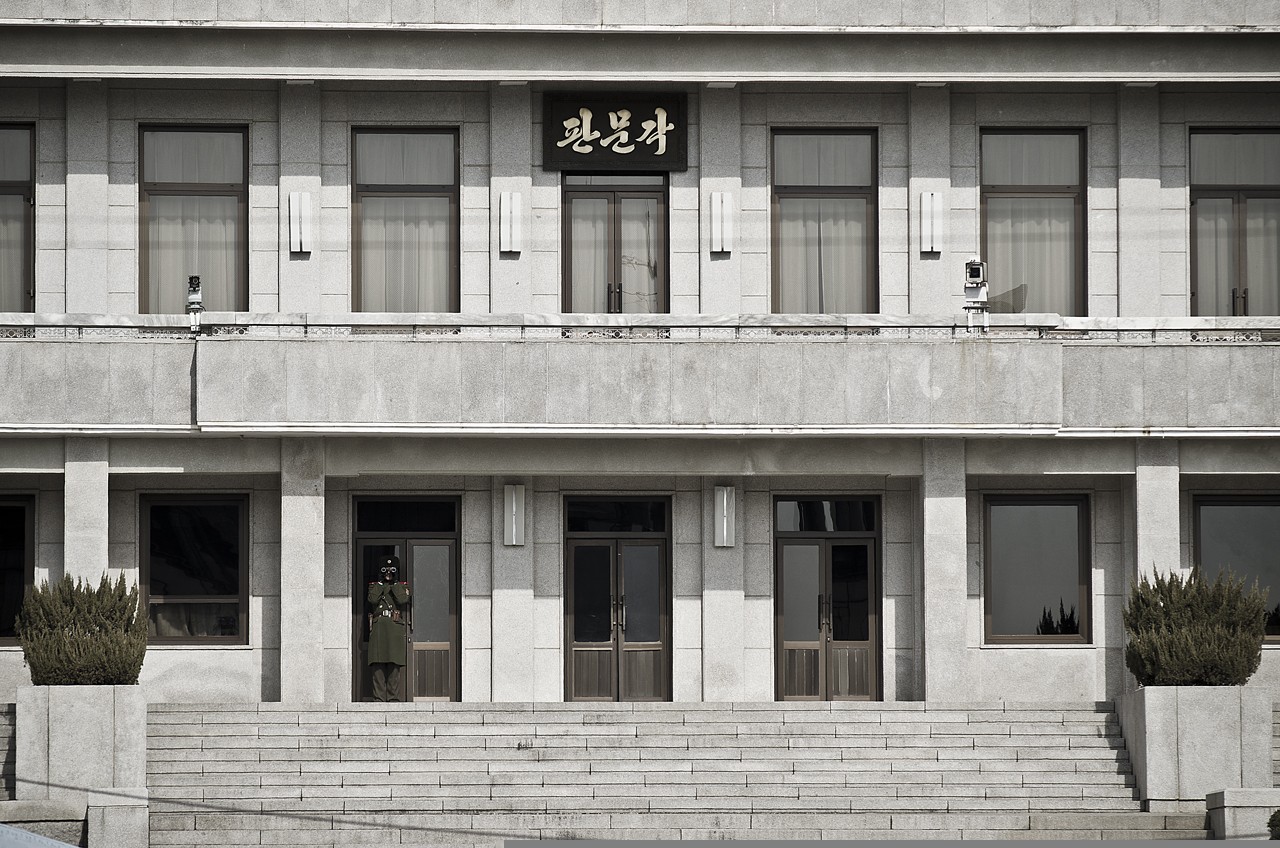 North Korea South Korea border tensions — a North Korean soldier watches through binoculars from the Panmungak building at Panmunjom in the DMZ
