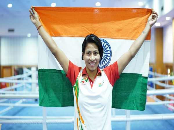 Lovlina Borgohain holds the Indian flag beside a boxing ring after an Asian championship success