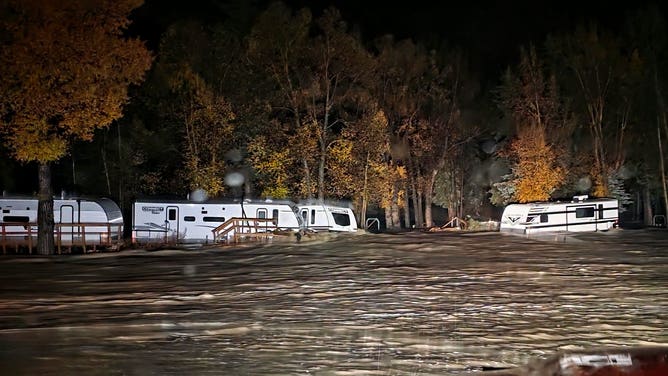 Four Corners flooding — recreational vehicles standing in fast-moving floodwater at night in South Fork, Colorado