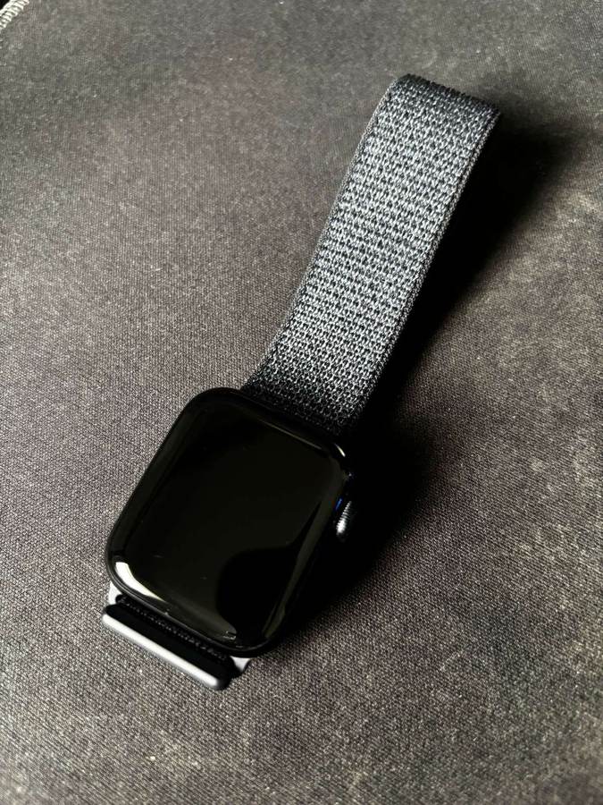Apple Watch SE 2 with a sport loop band resting on a dark surface