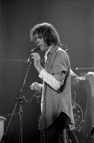 A young Neil Young singing into a microphone on stage in Austin, Texas in 1976 — file photo