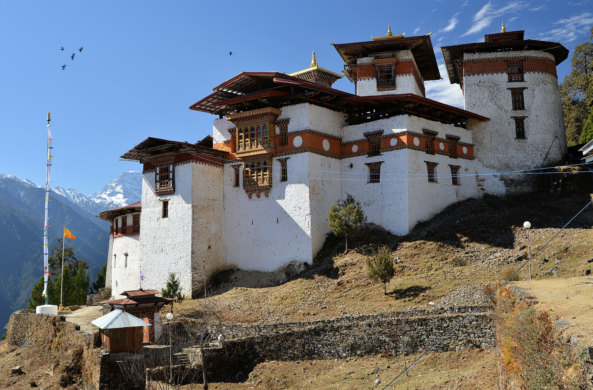 Gasa Dzong in Gasa district, northern Bhutan, with snow-covered Himalayan peaks behind it — the district hit by the Shintaphu Lake outburst and Bhutan GLOF October 2026