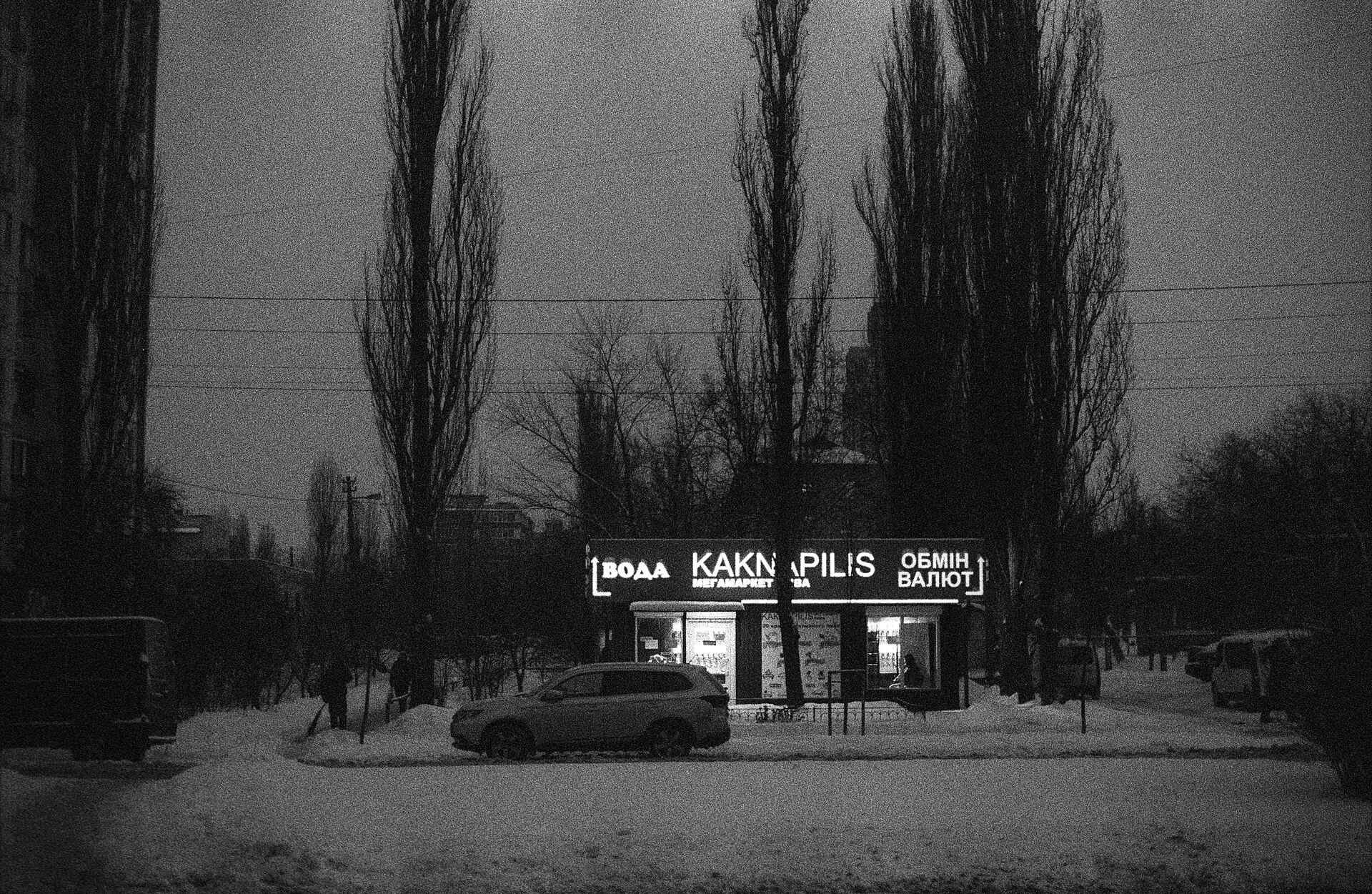 Snow-covered Kyiv street in blackout with one generator-lit shop glowing, file photo for Russia war crimes Ukraine energy attacks coverage