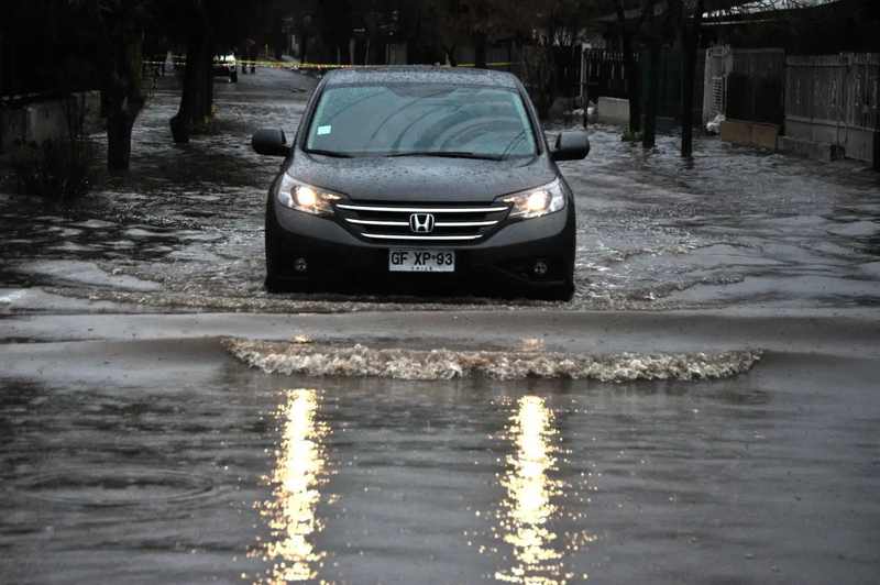 Car driving through a flooded Santiago street after the Mapocho River overflow
