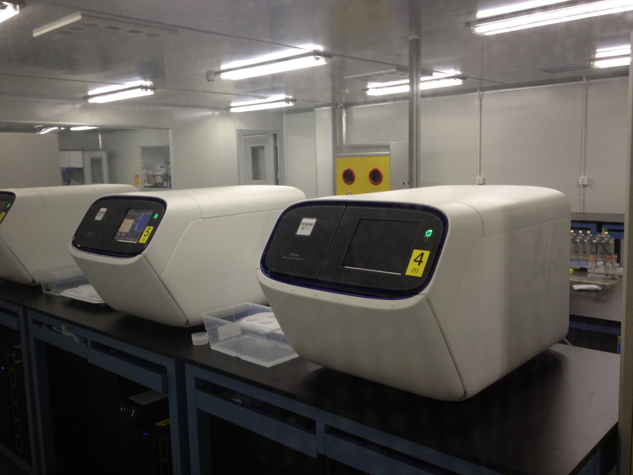 DNA gene-sequencing laboratory — a row of Ion Proton sequencing machines on benches inside BGI's Shenzhen facility