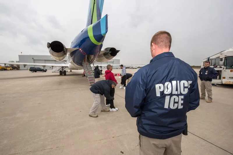 ICE officers beside an aircraft in a file photo illustrating third country deportation flights