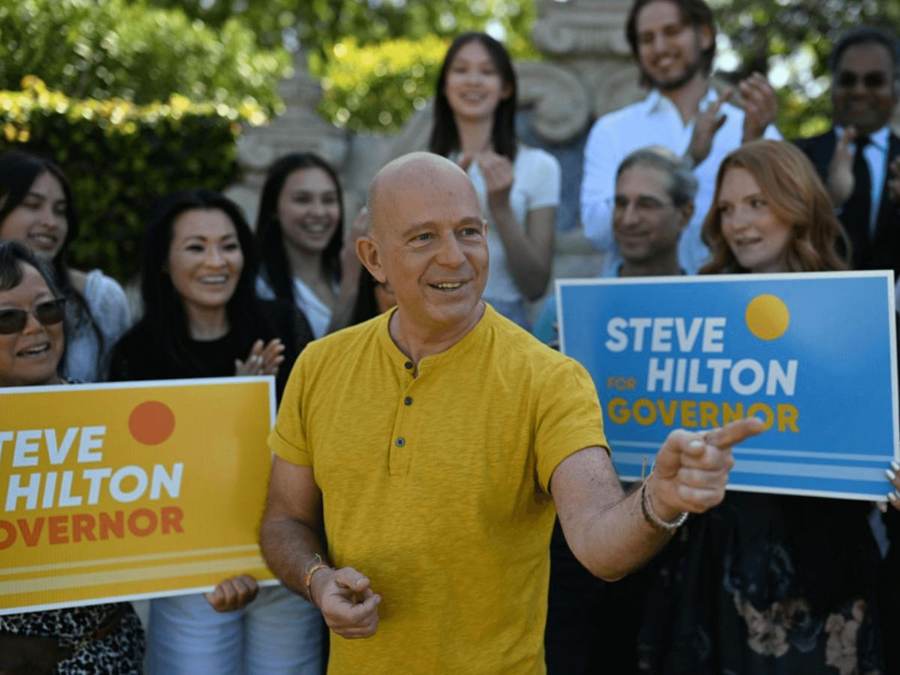 Republican California gubernatorial candidate Steve Hilton speaks at a campaign event, with supporters holding 'Steve Hilton for Governor' signs