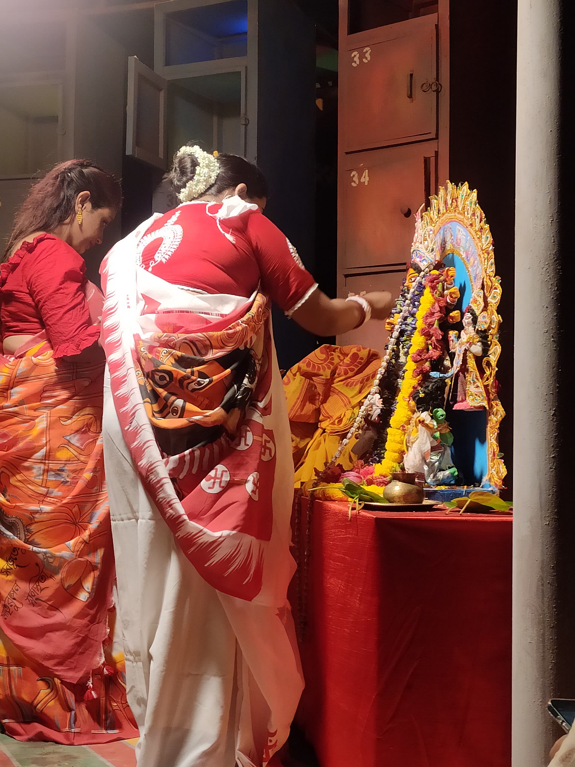 Women devotees in saris before a small Durga shrine at a Kolkata pandal on Dashami
