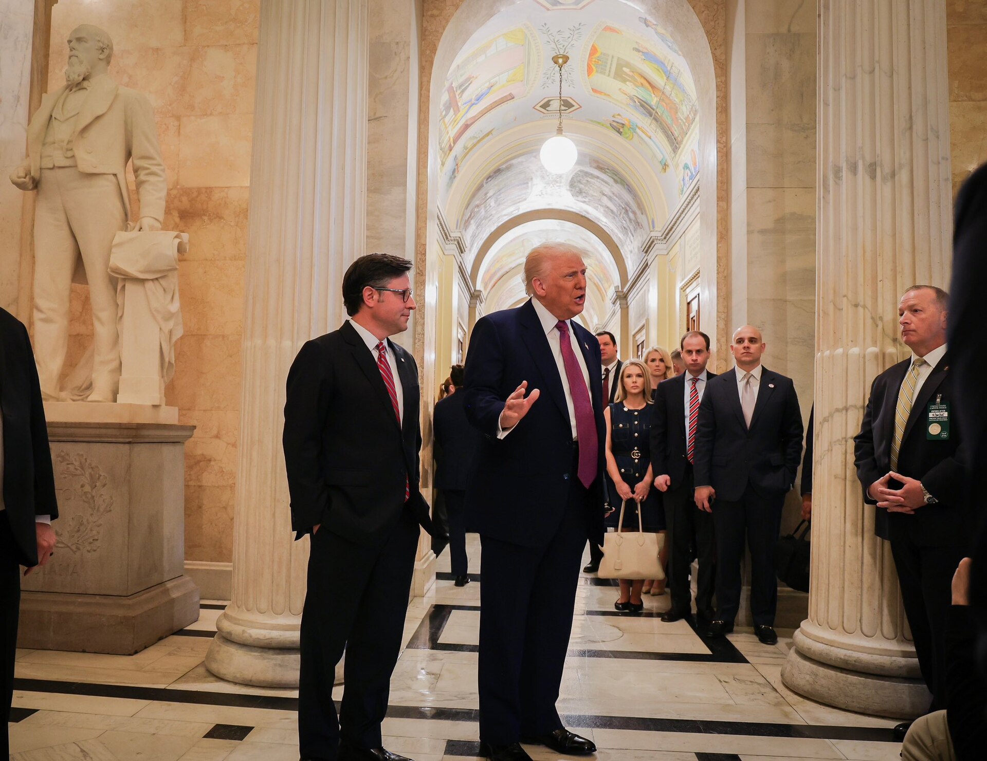 President Donald Trump speaking with Speaker Mike Johnson in a corridor at the U.S. Capitol