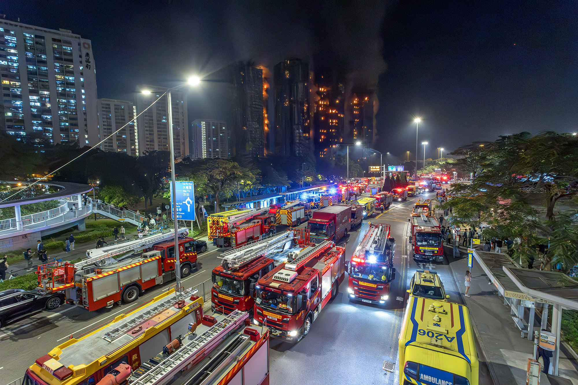 Fire engines and ambulances of the Hong Kong Fire Services Department on Tai Po Road below the burning Wang Fuk Court towers during the Hong Kong Tai Po fire that killed 168 people