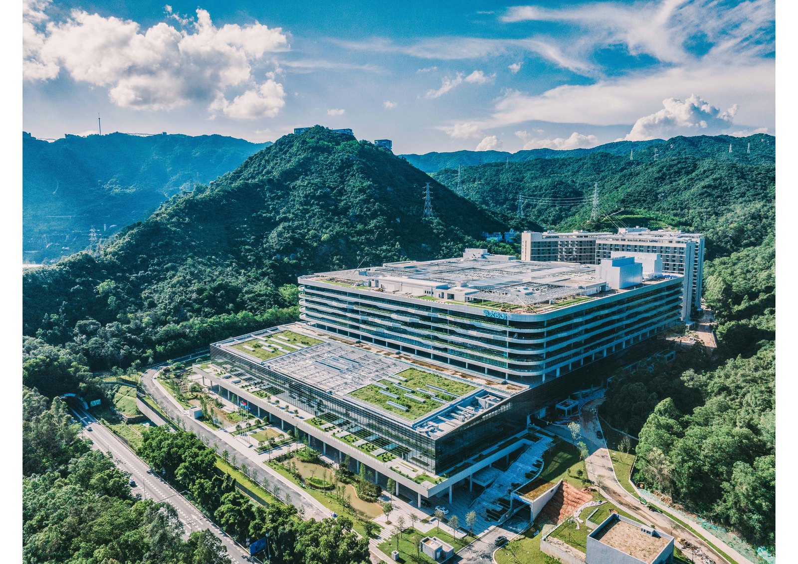 BGI Genomics import ban — aerial view of the BGI headquarters campus in Shenzhen, China, a terraced glass complex set against green hills