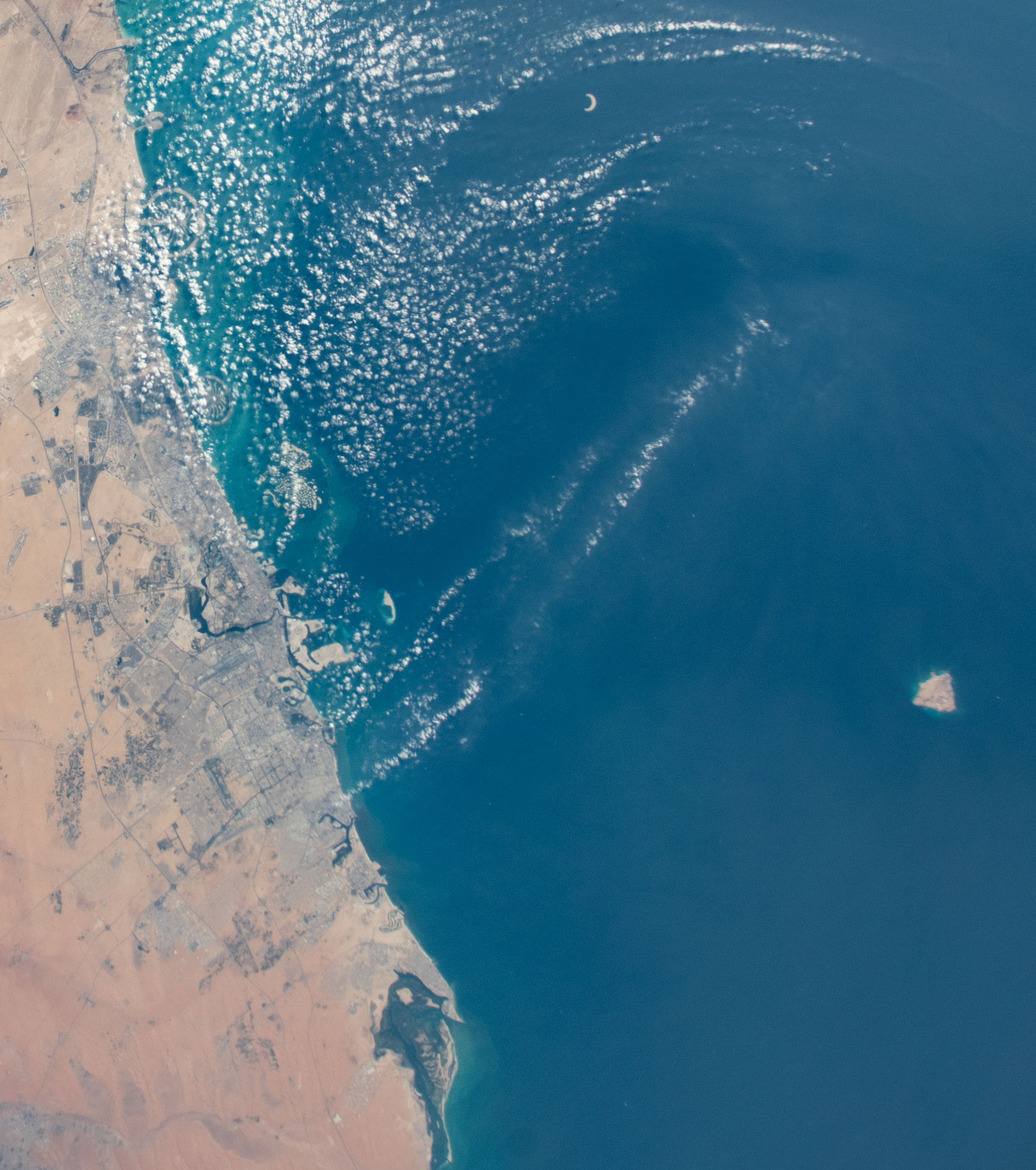 The UAE coast from Dubai through Sharjah toward Umm Al Quwain seen from the International Space Station, the shoreline now affected by the UAE oil spill