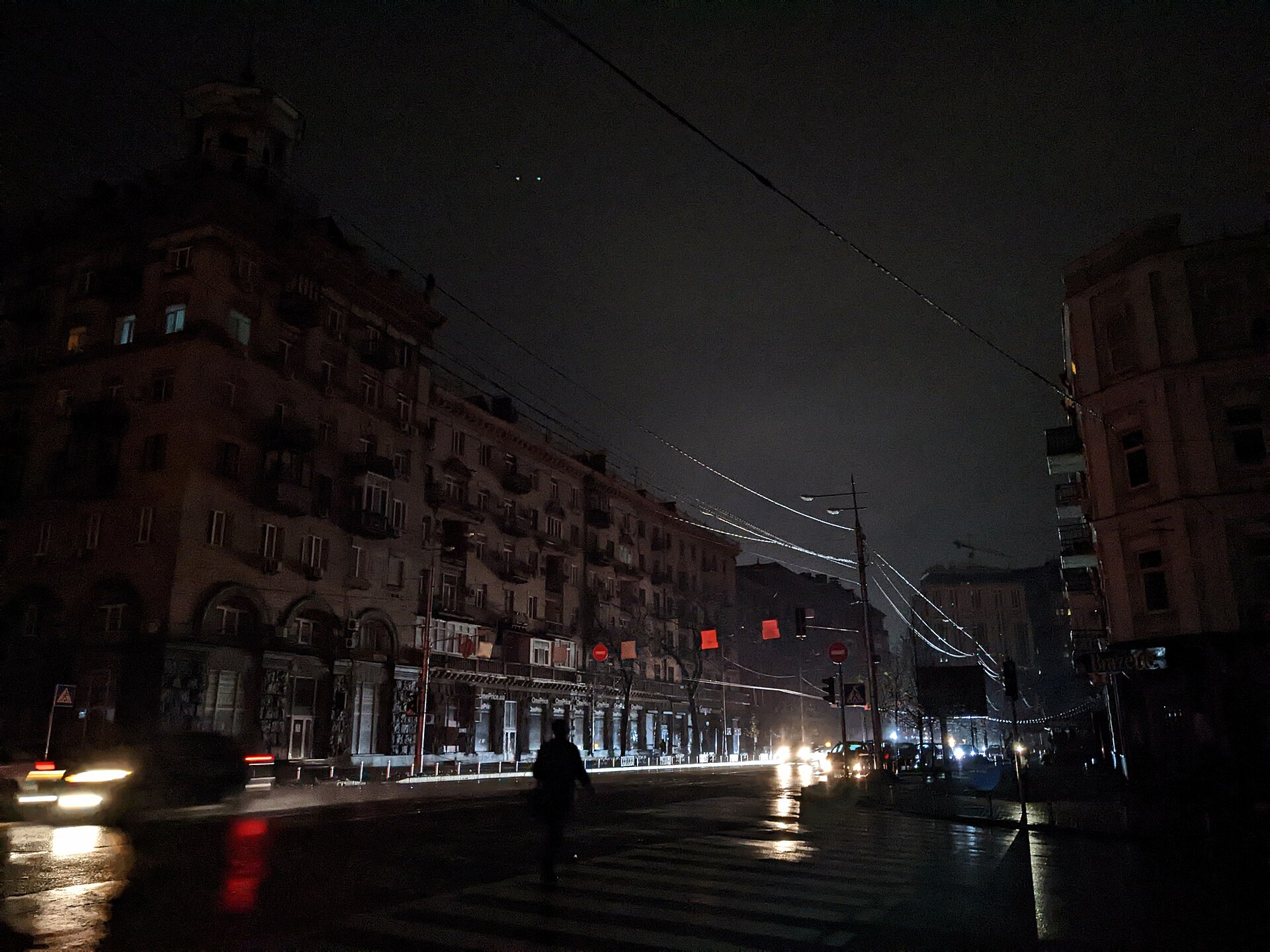 Velyka Vasylkivska Street in Kyiv at night during a blackout, apartment buildings dark and the street lit only by car headlights after Russian attacks on Ukraine's energy infrastructure — file photo