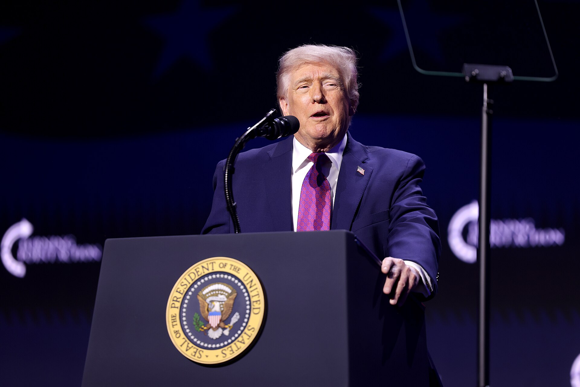Trump rally protester punched — President Donald Trump speaking at a presidential podium during his midterm rally tour