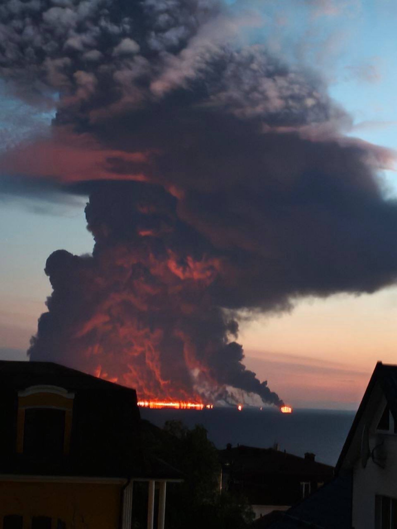 Black smoke column rising from a burning tanker off Sochi, seen from shore