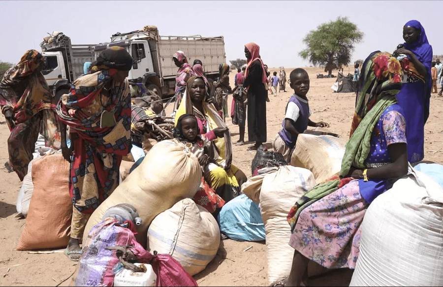 Sudanese refugee families in Chad gather with their belongings before transport to Gaga camp