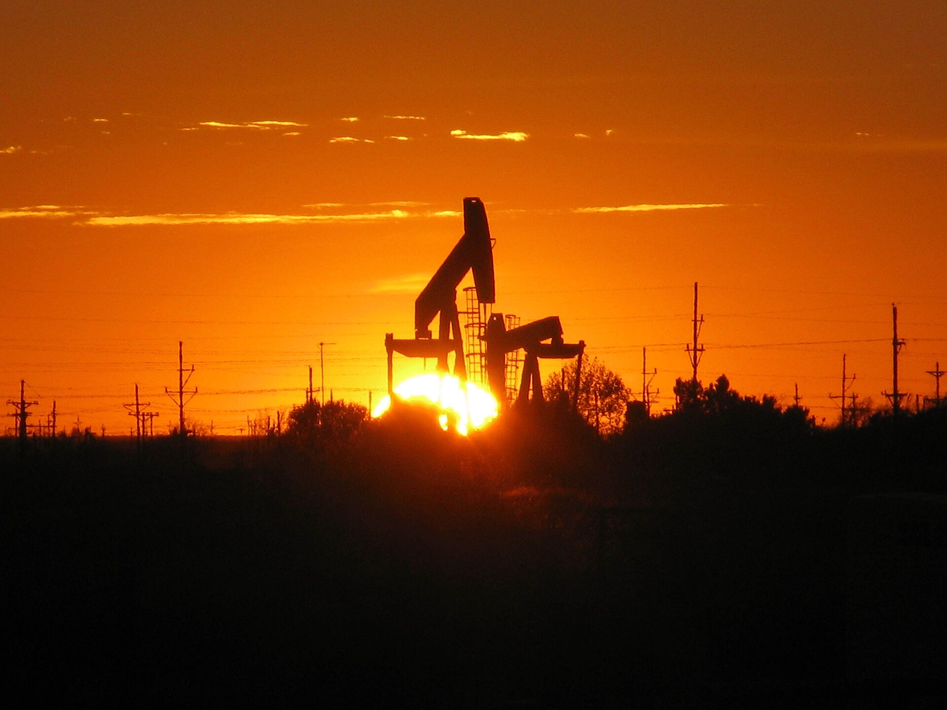 The sun setting behind a pump jack near Midland, Texas — file photo for stock market today October 23 2026 as WTI crude tops $100