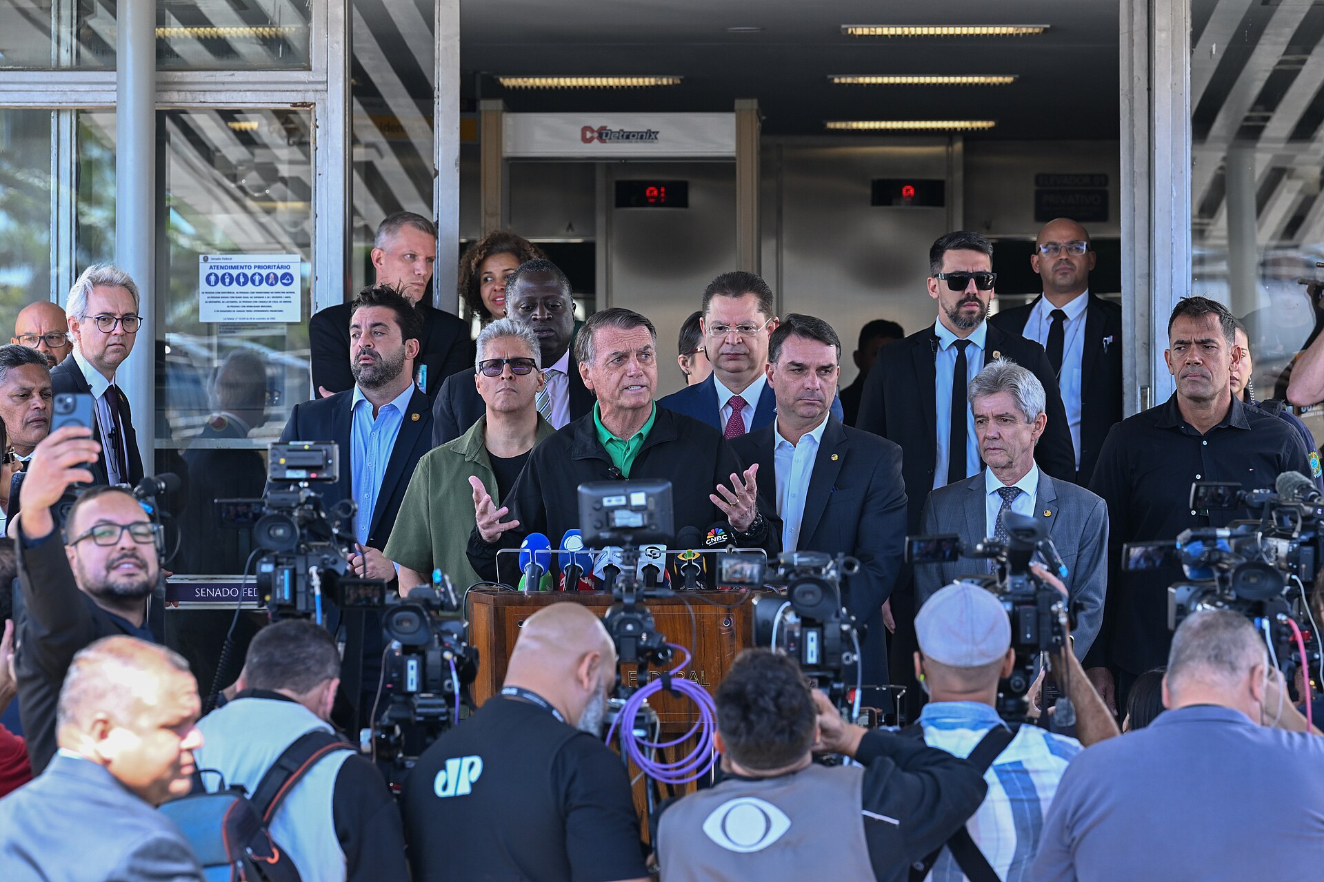 Flávio Bolsonaro standing beside his father Jair Bolsonaro at a Senate press conference in Brasília, July 2025