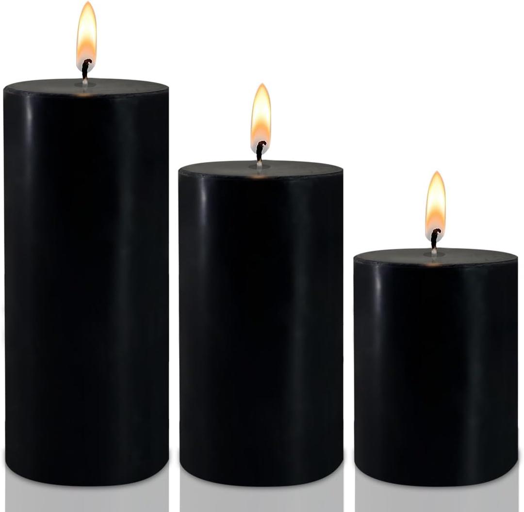 Three black candles burning against a white background