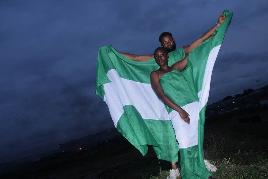 Nigerians celebrating Nigeria's independence anniversary draped in the national flag