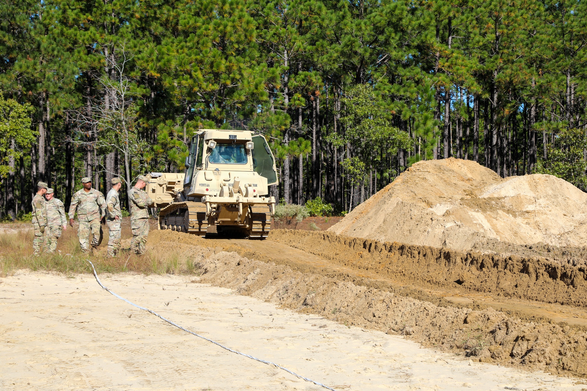 A combat engineer of the 20th Engineer Brigade operates a D6 bulldozer to excavate a simulated burial site at Fort Bragg during Operation Dragon Covenant