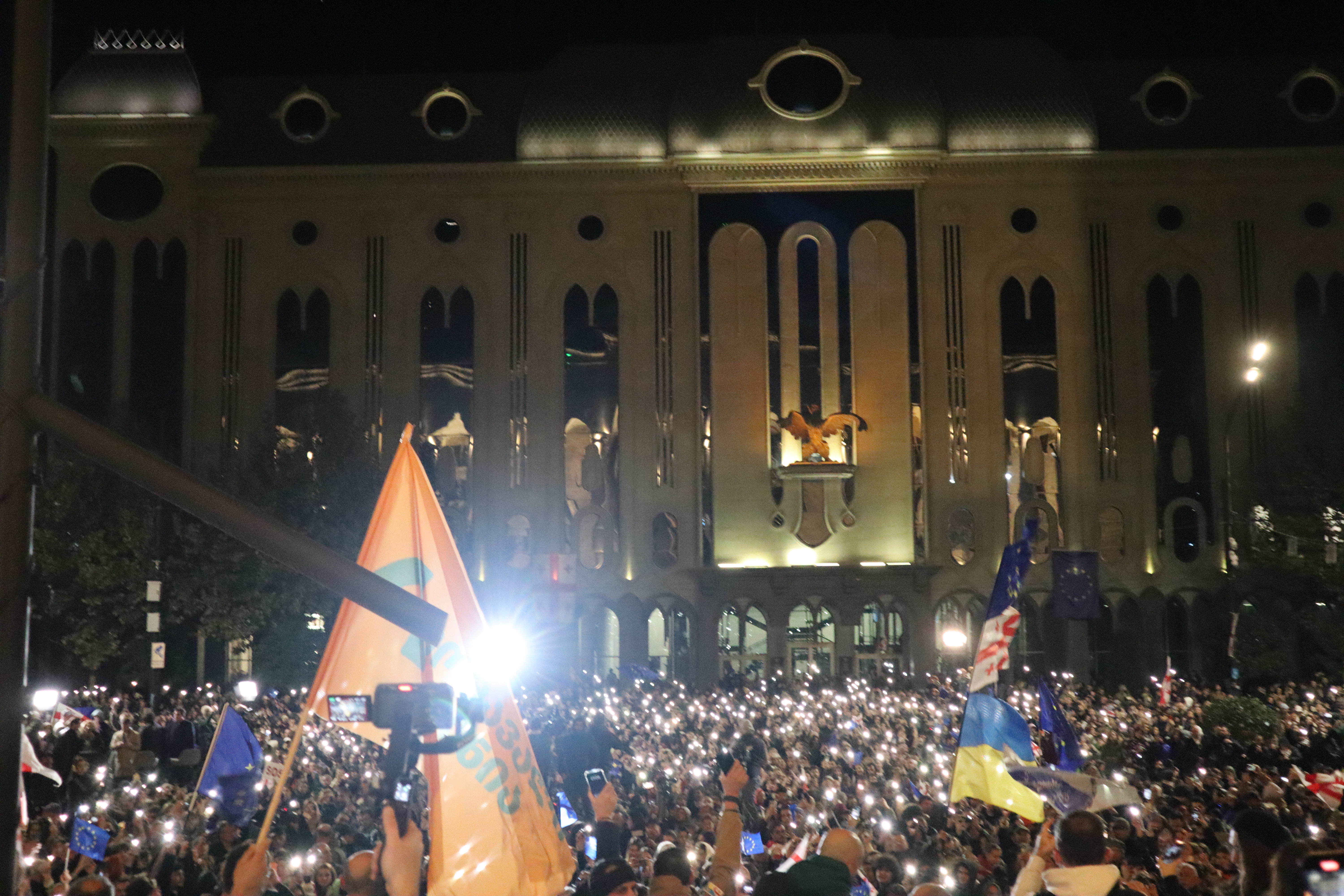 Georgia opposition parties ban — opposition supporters with Georgian and European Union flags outside parliament in Tbilisi after the 2024 elections