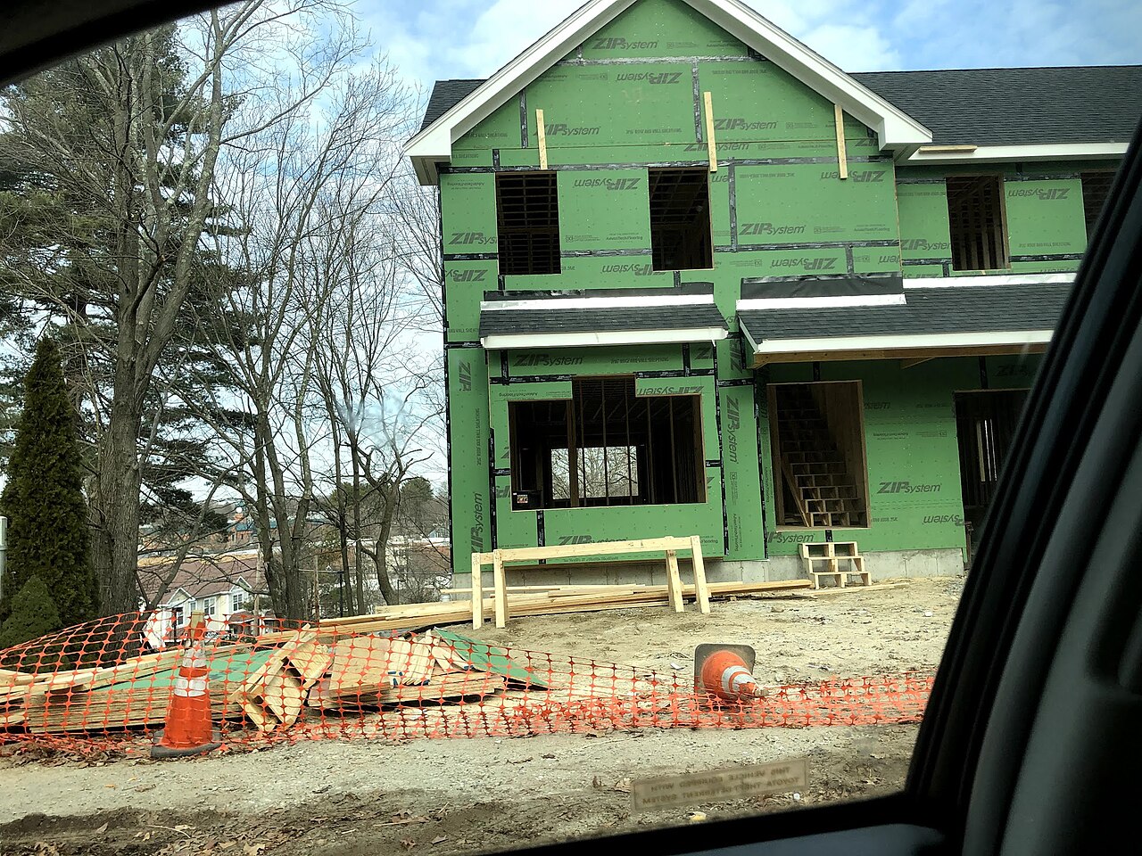 Single-family house under construction with framing and sheathing underway — US housing shortage context for Trump housing executive order