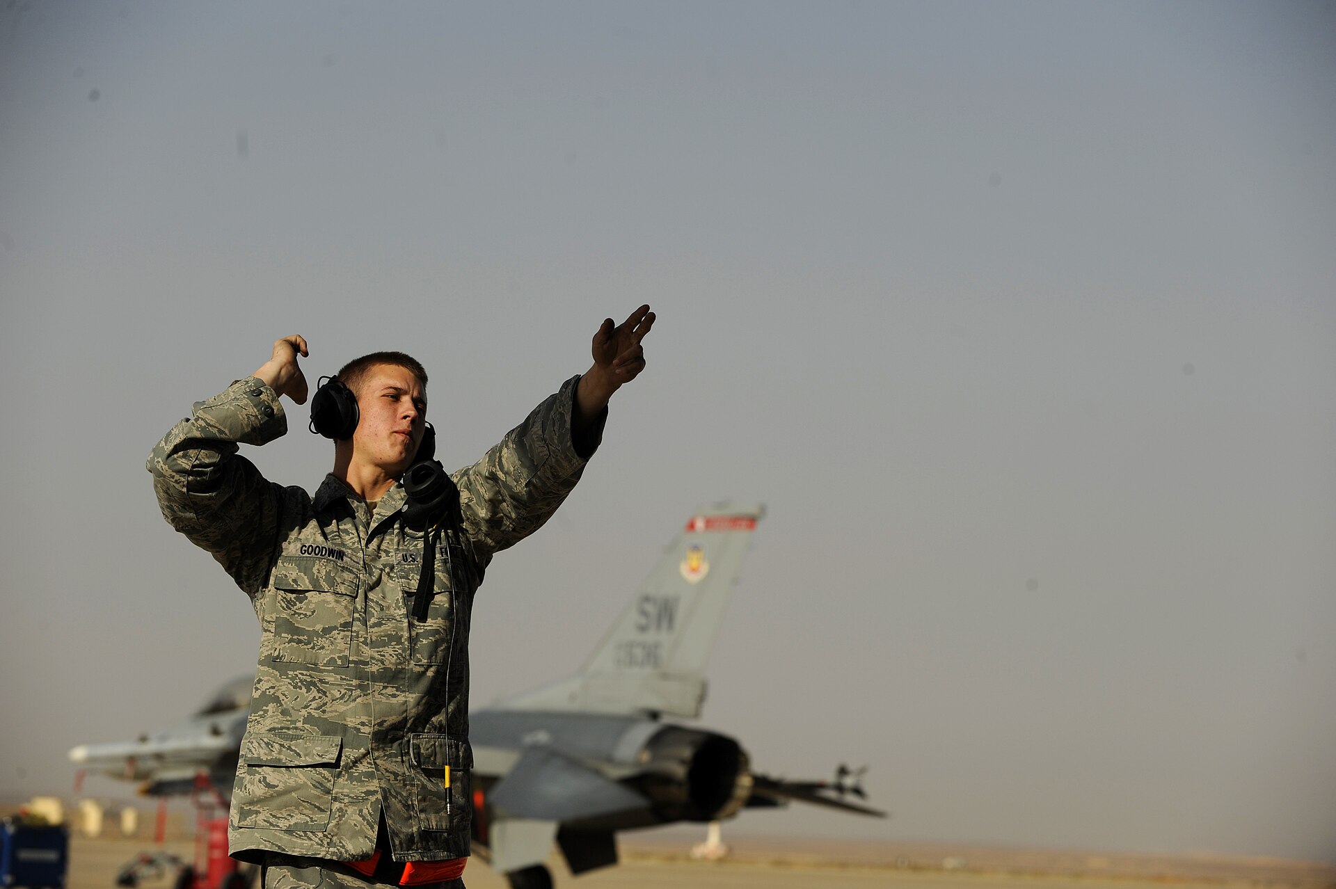 A U.S. airman marshals an F-16 fighter at Muwaffaq Salti Air Base in Azraq, Jordan, during a Falcon Air Meet — Jordan airstrikes southern Syria were flown by the Royal Jordanian Air Force