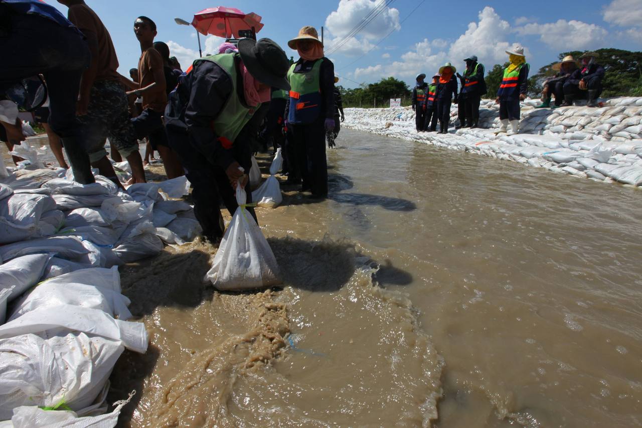 Volunteers and Thai military personnel filling sandbags in floodwater in Sai Mai Bangkok during the 2011 floods, file photo