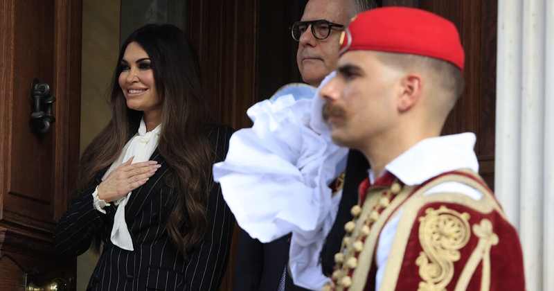 Ambassador Kimberly Guilfoyle at a ceremonial arrival in Athens, Greece, beside a presidential guard