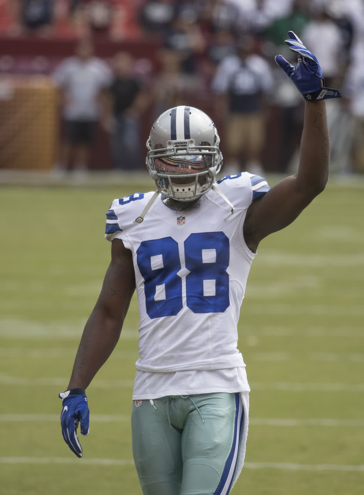 Dez Bryant in his Cowboys number 88 jersey raising a hand to the crowd in 2016 — file photograph