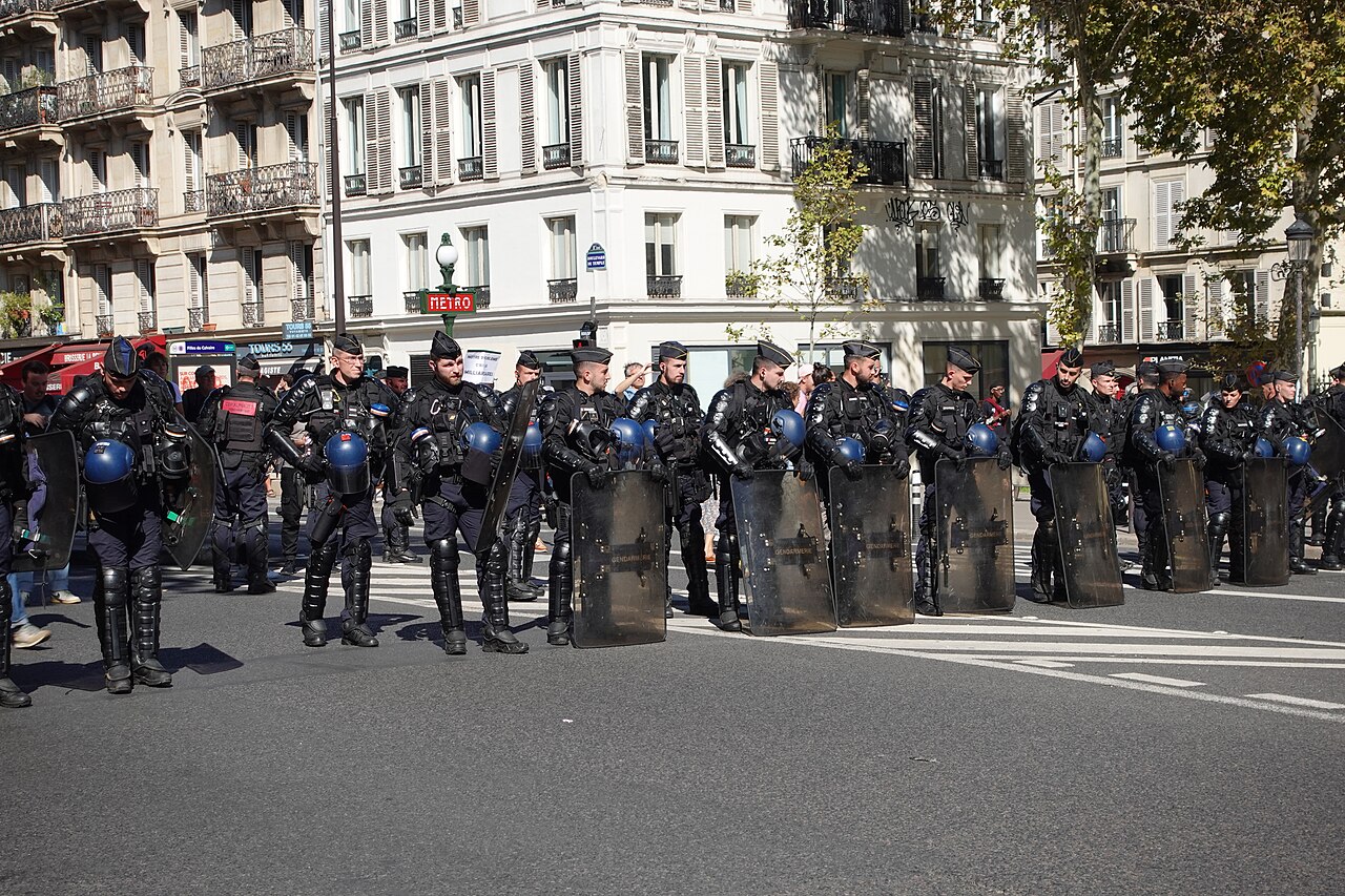 French riot police lined up with shields on a Paris street during a demonstration in France