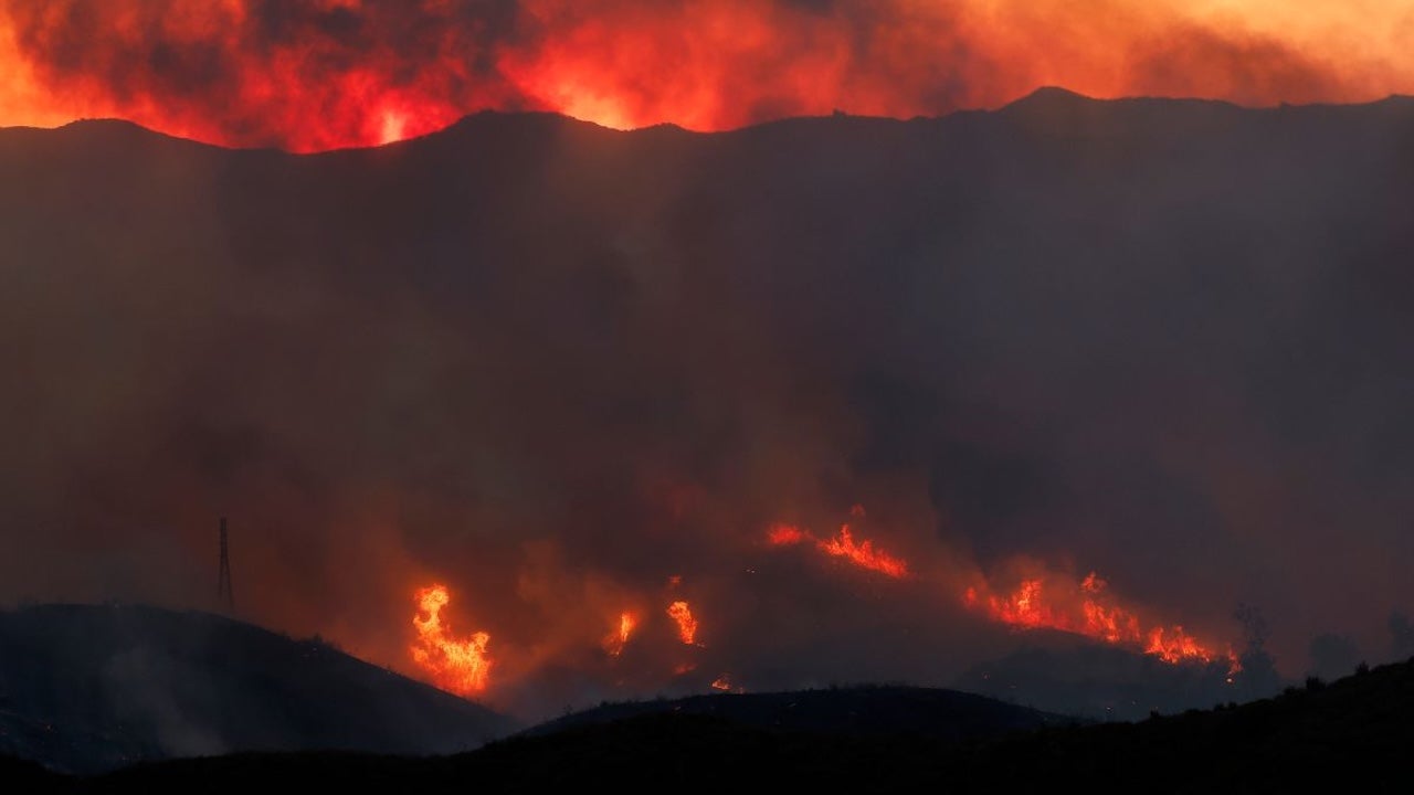 Lines of flame burn along dark ridgelines above Malibu as the Bryson Fire spreads at dusk
