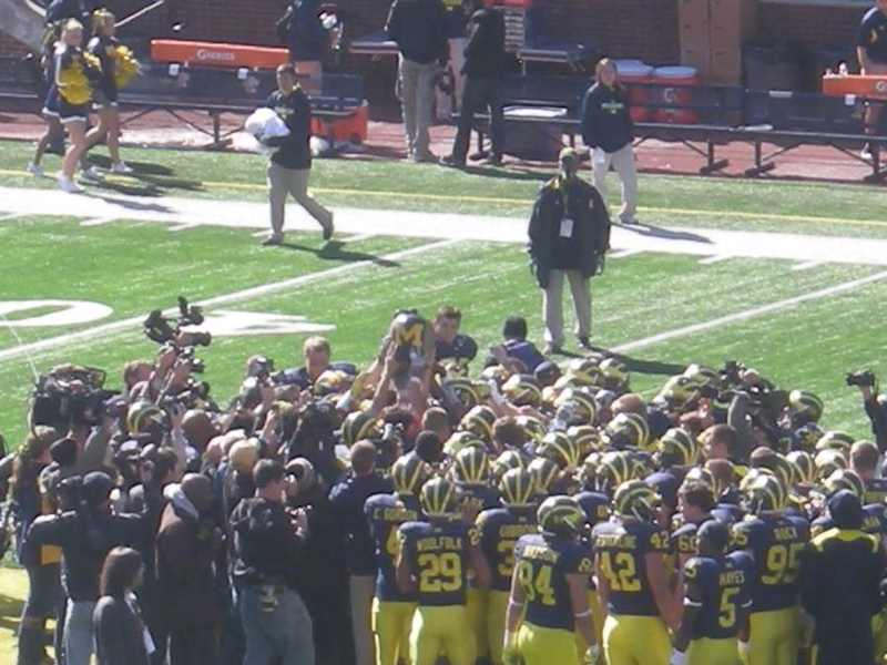Michigan players carrying the Little Brown Jug after the 2011 Minnesota rivalry game