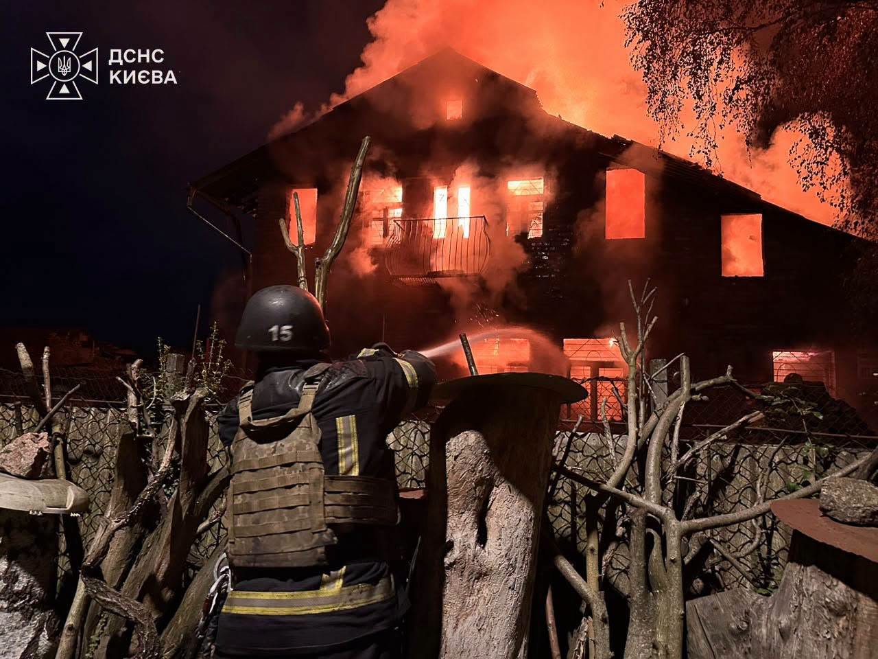 A Kyiv firefighter hoses a burning house during the response to a Russian attack on the capital — State Emergency Service file photo