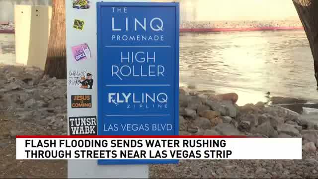 The LINQ Promenade sign at Las Vegas Boulevard with floodwater behind it during the October 2026 Las Vegas flash flood