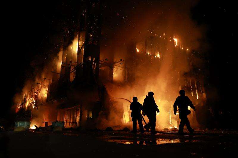 Rescue workers at the burning Intrade trade center in Zaporizhzhia after a Russian drone strike