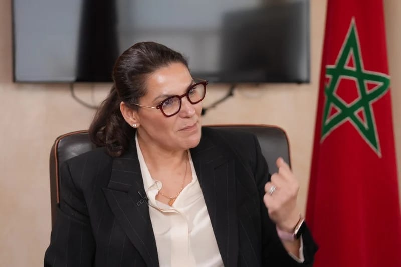 Fatima Ezzahra El Mansouri, Morocco's first woman prime minister, speaking at a party event with the Moroccan flag behind her — King Mohammed VI appointed her on September 29, 2026